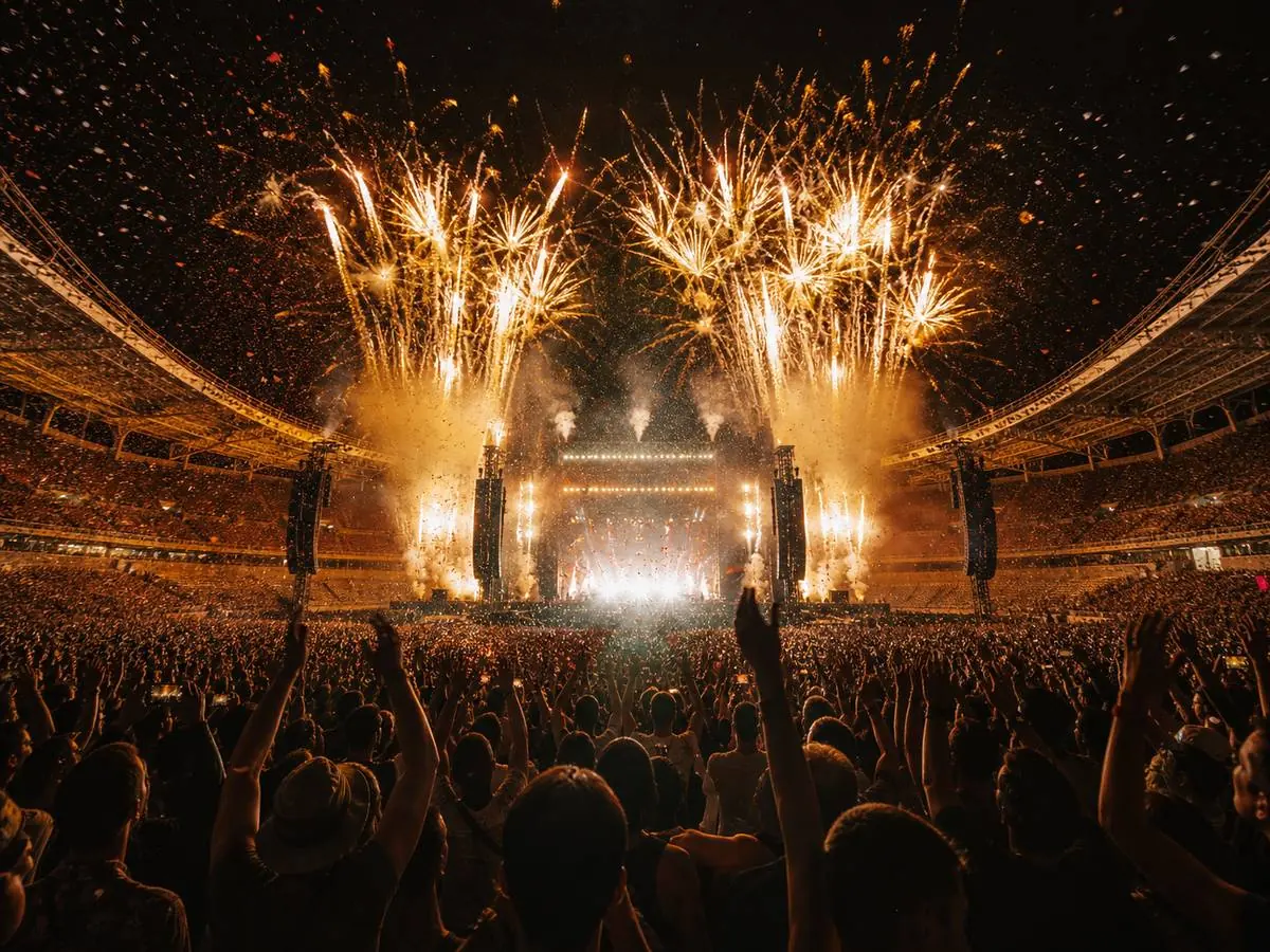 Fireworks over a stadium stage at the end of a show